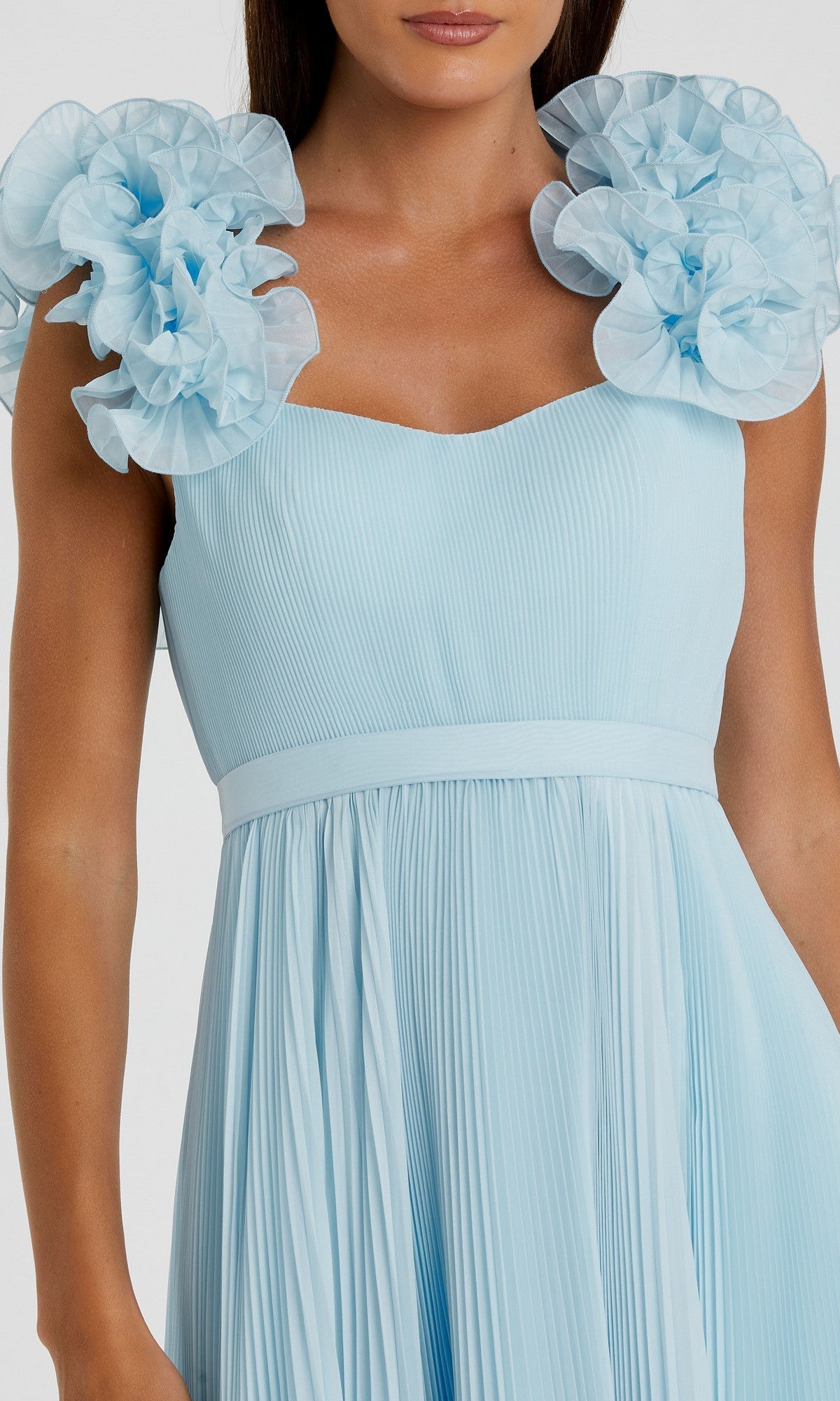 Model wears the Mac Duggal 49979 long formal dress, a light blue pleated organza design featuring large ruffled floral shoulder details, shown from shoulders to mid-thigh. Elegant and textured for a standout look.